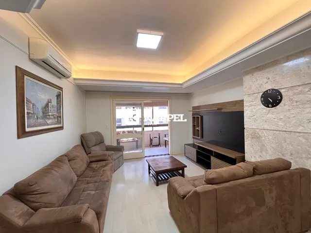 Sala de estar com sofá e piso de madeira clara.