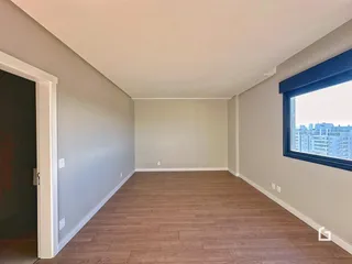 Ambiente interno com piso de madeira e paredes cinzas.