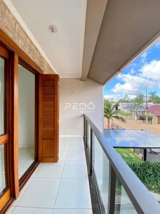 Vista interna de uma sala com porta de madeira e vista para o exterior.