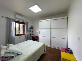 Quarto com cama e guarda-roupa branco.