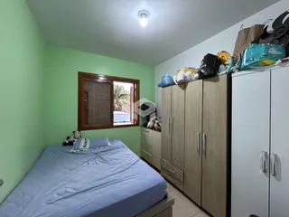 Quarto com cama e armários de madeira em um imóvel no Brasil.
