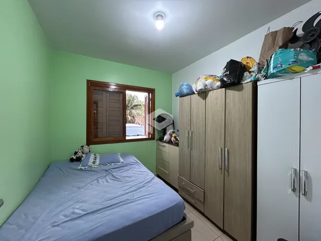 Quarto com cama e armários de madeira em um imóvel no Brasil.