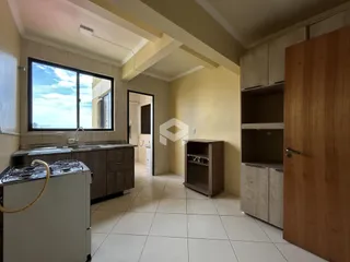 Vista interna de uma cozinha com piso de cerâmica e janela grande.