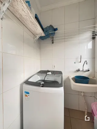 Foto de um banheiro com paredes brancas e azulejos.