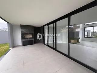 Sala de estar com piso de concreto e grandes portas de vidro.