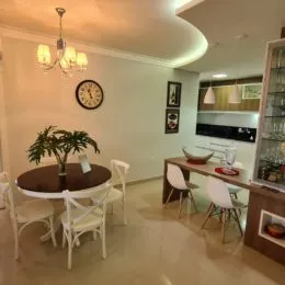 Sala de estar com mesa redonda e iluminação clara em um imóvel.
