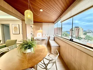 Sala de jantar com piso de madeira e vista para a paisagem urbana.