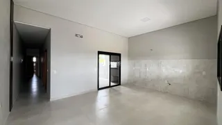 Hall de entrada com paredes brancas e piso de concreto.