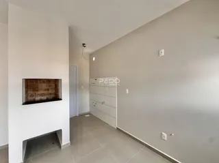 Hall de entrada com parede de tijolo aparente e armário branco.