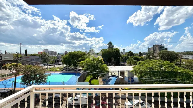 Vista externa de uma propriedade com piscina e jardim.