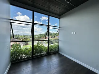 Ambiente interno com grande janela de vidro que oferece vista para o exterior.