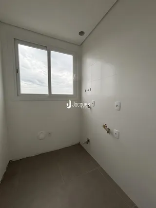 Vista interna de um cômodo com parede branca e piso de cerâmica.