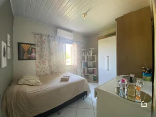 Quarto com cama e janela bem iluminada.