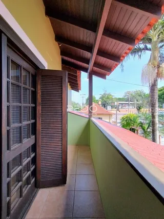 Vista de uma varanda com estrutura de madeira e grade.