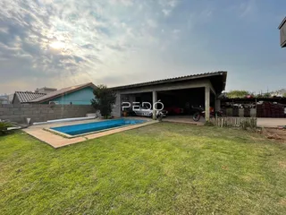 Vista externa de uma propriedade com piscina e jardim.