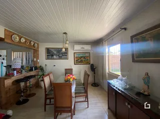 Foto de uma sala de jantar com mesa de madeira e decoração de parede em Lajeado.
