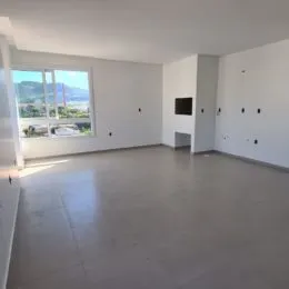 Foto de uma sala ampla com grandes janelas que dão vista para o exterior.