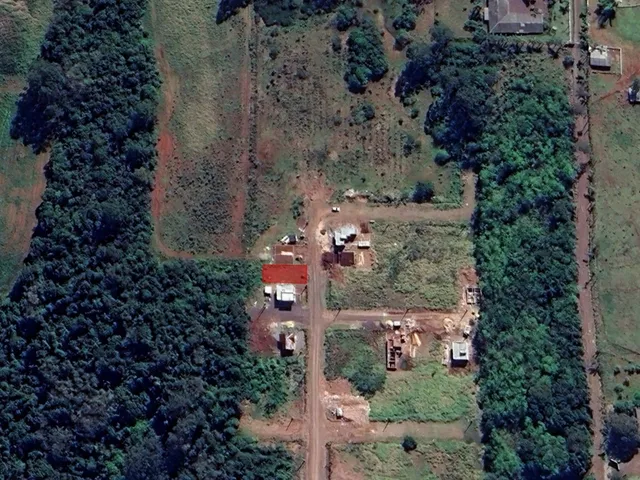 Vista aérea do terreno com vegetação densa ao redor da construção.