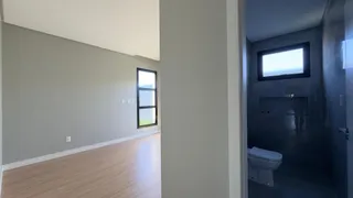 Hall de entrada com piso de madeira clara e parede neutra em um imóvel.