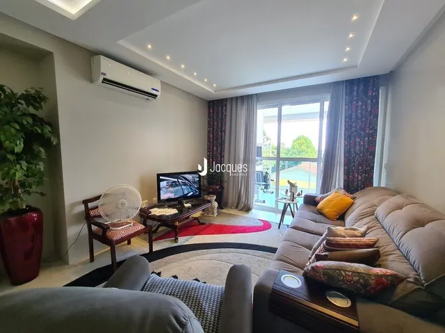 Sala de estar com sofá e televisão em um apartamento.