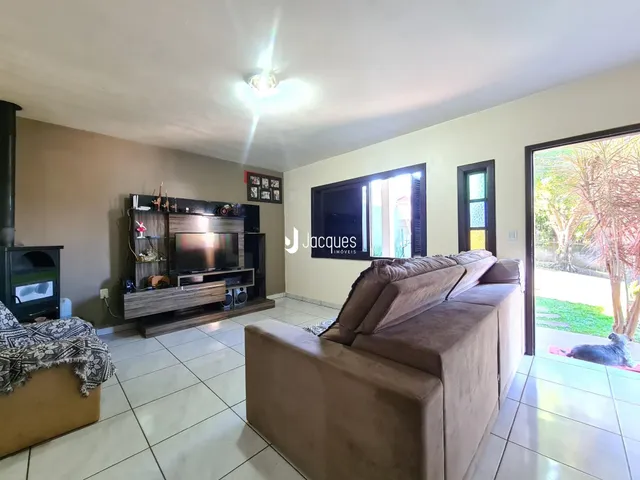 Sala de estar com sofá e televisão em um imóvel no Brasil.