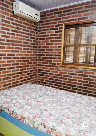 Quarto com paredes de tijolo aparente e cama.