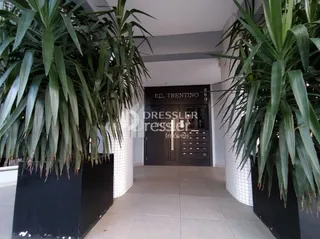 Passagem interna de um imóvel em Lajeado, Brasil, com plantas grandes nas paredes.