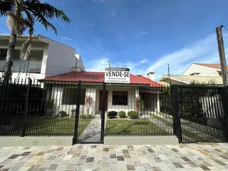 Fachada de uma residência com telhado vermelho e cerca frontal.