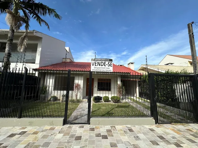 Fachada de uma residência com telhado vermelho e cerca frontal.
