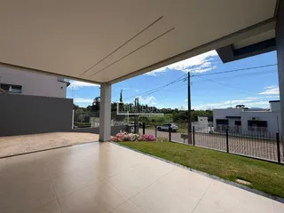 Área externa com piso de concreto e cerca de metal de uma propriedade em Lajeado.