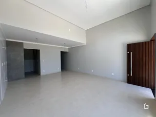 Espaço interno amplo com paredes brancas e piso claro.