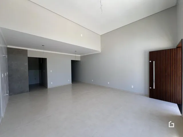 Espaço interno amplo com paredes brancas e piso claro.
