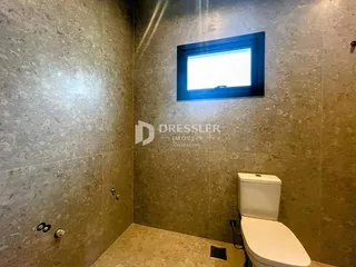 Foto de um banheiro com paredes de azulejo e janela.