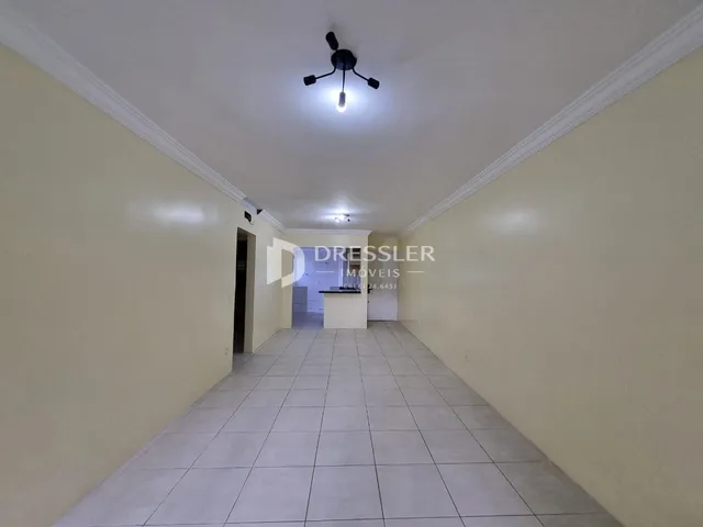 Corredor interno de uma residência com piso de cerâmica.