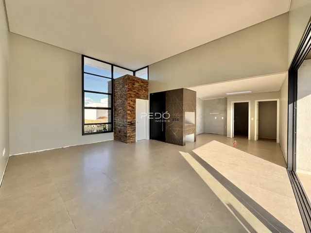 Sala de estar ampla com piso de cerâmica e grandes janelas.