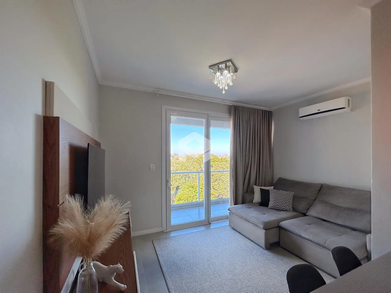 Sala de estar com porta de vidro abrindo para a varanda