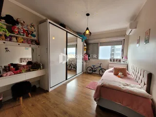 Quarto com armário e cama em ambiente interno.