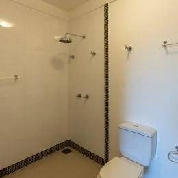 Foto interna de um banheiro com vaso sanitário branco.
