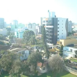 Vista externa da propriedade com vegetação e árvores.