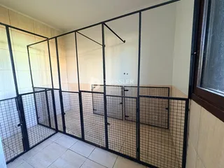 Interior de um ambiente com divisória de metal e azulejos brancos.