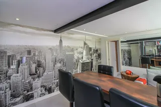 Ambiente com mural de paisagem urbana na parede.