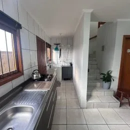 Hall de corredor com janela e piso de cerâmica em imóvel em Lajeado.