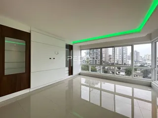 Sala de estar com grandes janelas que oferecem vista da cidade.