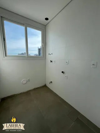 Vista interna de um cômodo com grande janela e piso de cerâmica.