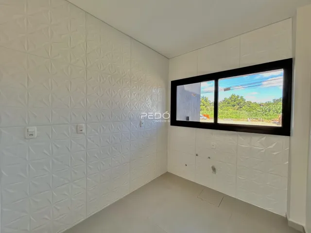 Ambiente interno com paredes brancas texturizadas e piso claro.