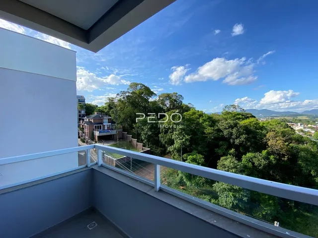 Vista da varanda com paisagem verde e vegetação.