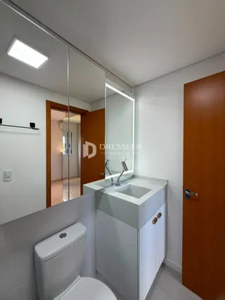 Foto de um banheiro com louças brancas e bancada clara.