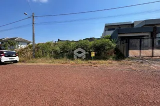 Fachada de uma propriedade com vegetação e estrada no primeiro plano.