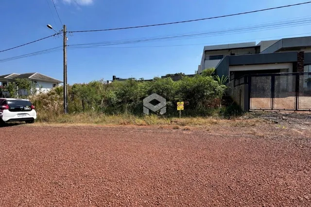 Fachada de uma propriedade com vegetação e estrada no primeiro plano.