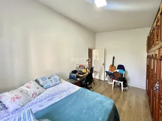 Quarto com cama e armário de madeira em um imóvel no Brasil.